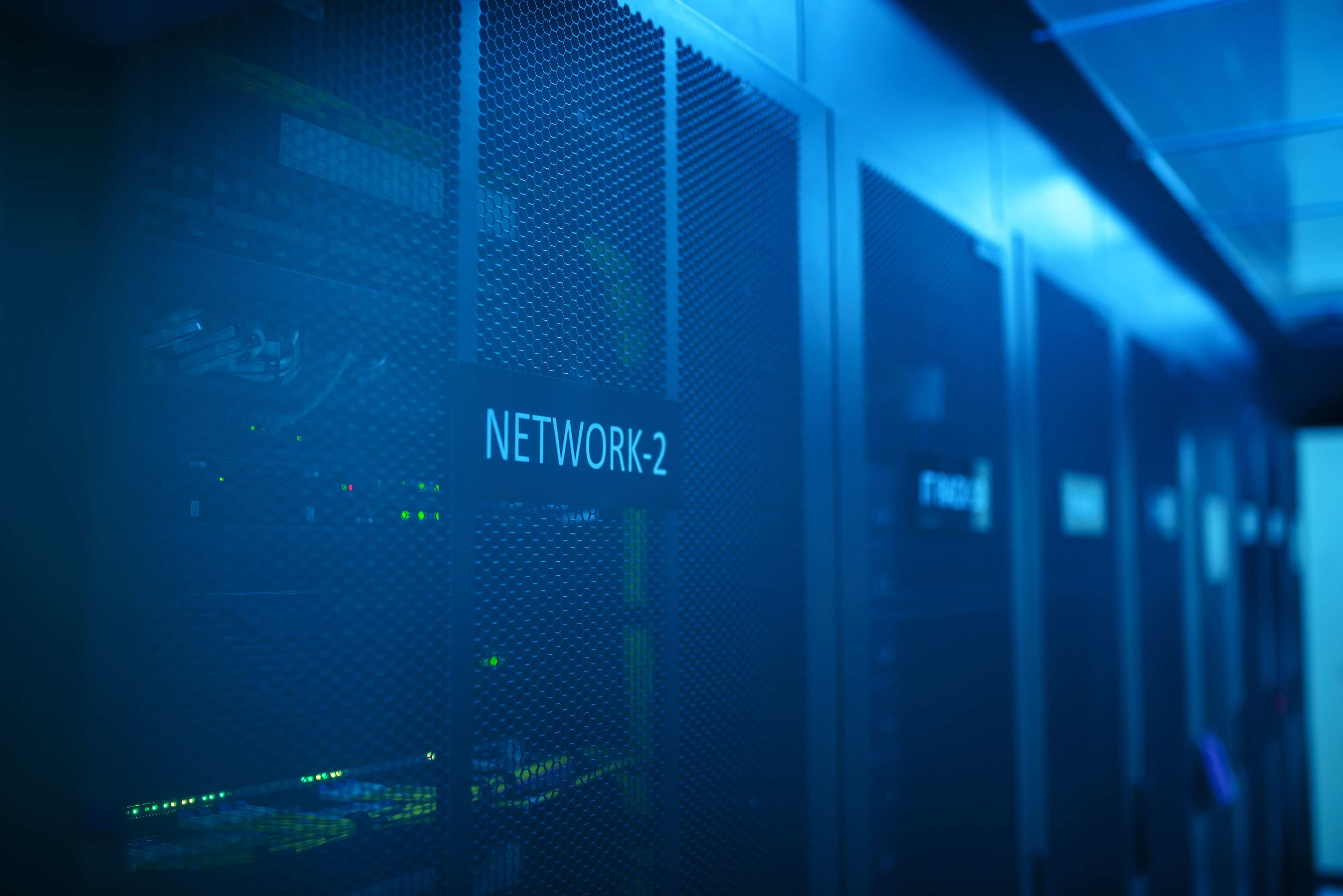 Row of server racks in a cooled equipment room with network cabling
